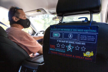 A guest rating placard hangs from the passenger seat of Hector Castellanos' car.