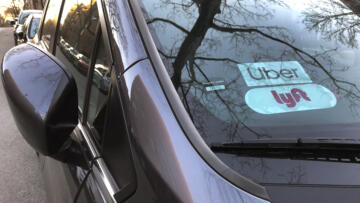 Uber and Lyft sign in windshield of car, Queens, New York.