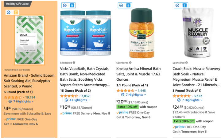 Screenshot of an Amazon search page for bath salts, with the first result (Solimo Epson Salt) surrounded by the Brand Detector app's orange. There is a small c in a yellow square above the image in the result, indicating the Fakespot grade.