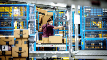 Photo of a worker sorting out parcels in the outbound dock at Amazon fulfillment center in Eastvale, CA.