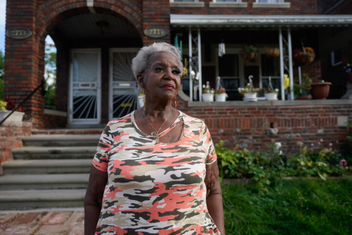68-year-old Pamela Jackson-Walters stands in front of her red brick house.