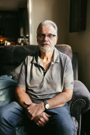 Gary Gray sits on a chair in his home in Olathe, Kan.