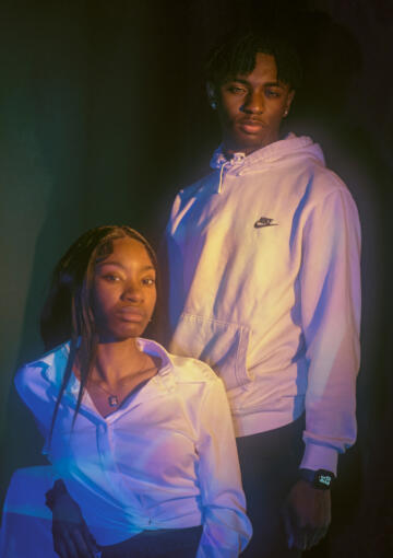 Photo of Mia Townsend and Maurice Newton, two young Black teenagers. Mia is seated and wearing a white collared shirt. Maurice is wearing a white Nike hoodie.