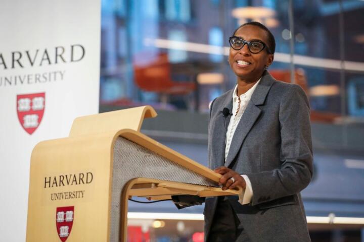 Photograph of Claudine Gay standing at a lectern imprinted with Harvard University’s logo