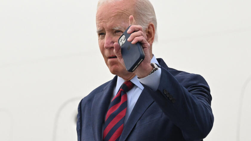 Photograph of US President Joe Biden holding a smartphone
