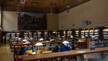 Wide-angle interior photograph of students studying in a college library