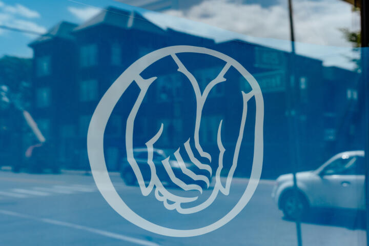 Photograph of a window display featuring the Allstate logo of two hands cupped together