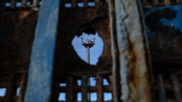 A surveillance tower is seen through a hole on the US-Mexico border wall in Playas de Tijuana, Baja California state, Mexico