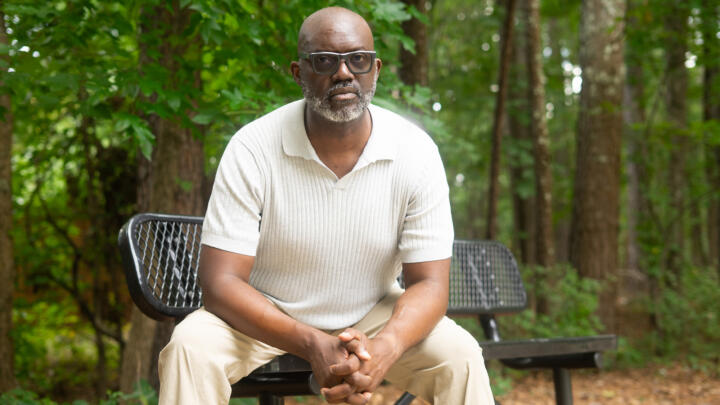 Craig Meritt sitting at an outdoor bench in a park